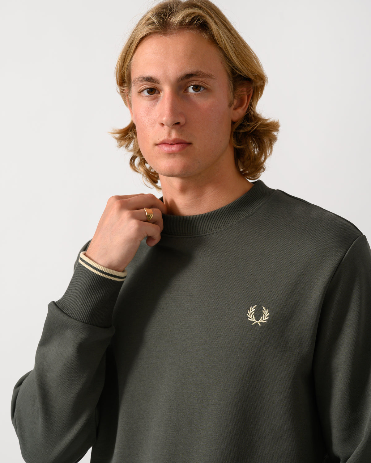 close up studio photograph of a model wearing Fred Perry Mens Crew Neck Sweatshirt in Field Green/Oatmeal U98