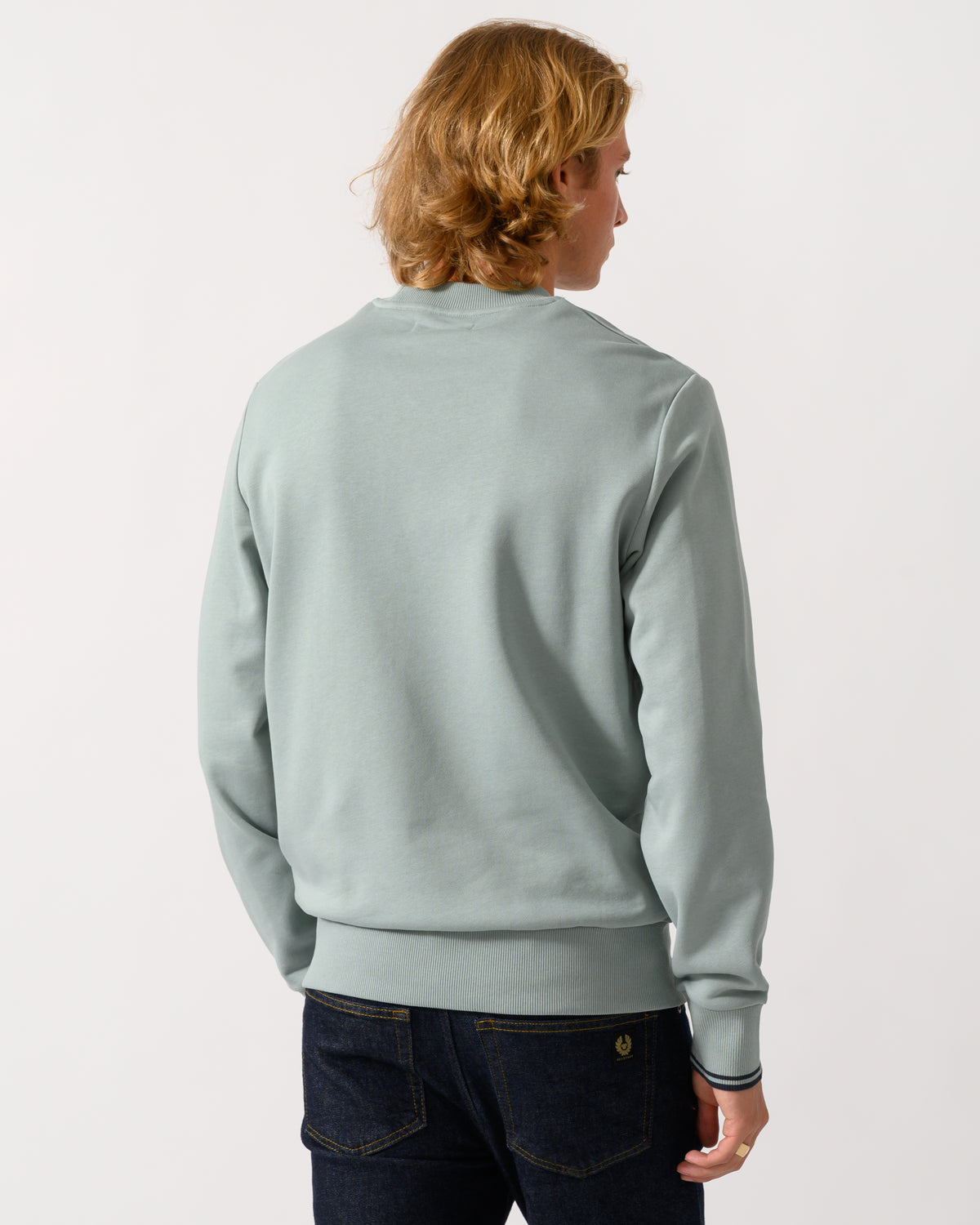 studio photograph showing back of a model wearing a Fred Perry Mens Crew Neck Sweatshirt in Silver Blue/Dark Airforce 71C
