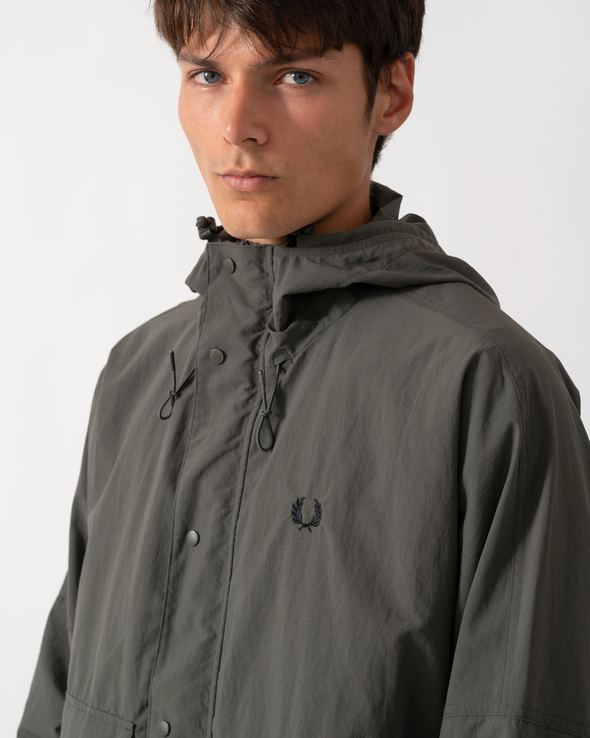 close up of a model wearing a Fred Perry Mens Cropped Ripstop Parka in Field Green D09