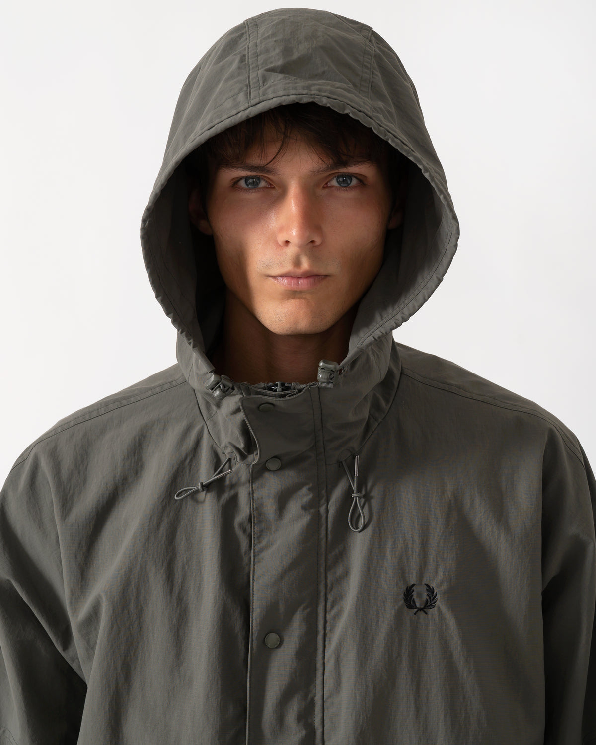 hood detail of a model wearing a Fred Perry Mens Cropped Ripstop Parka in Field Green D09