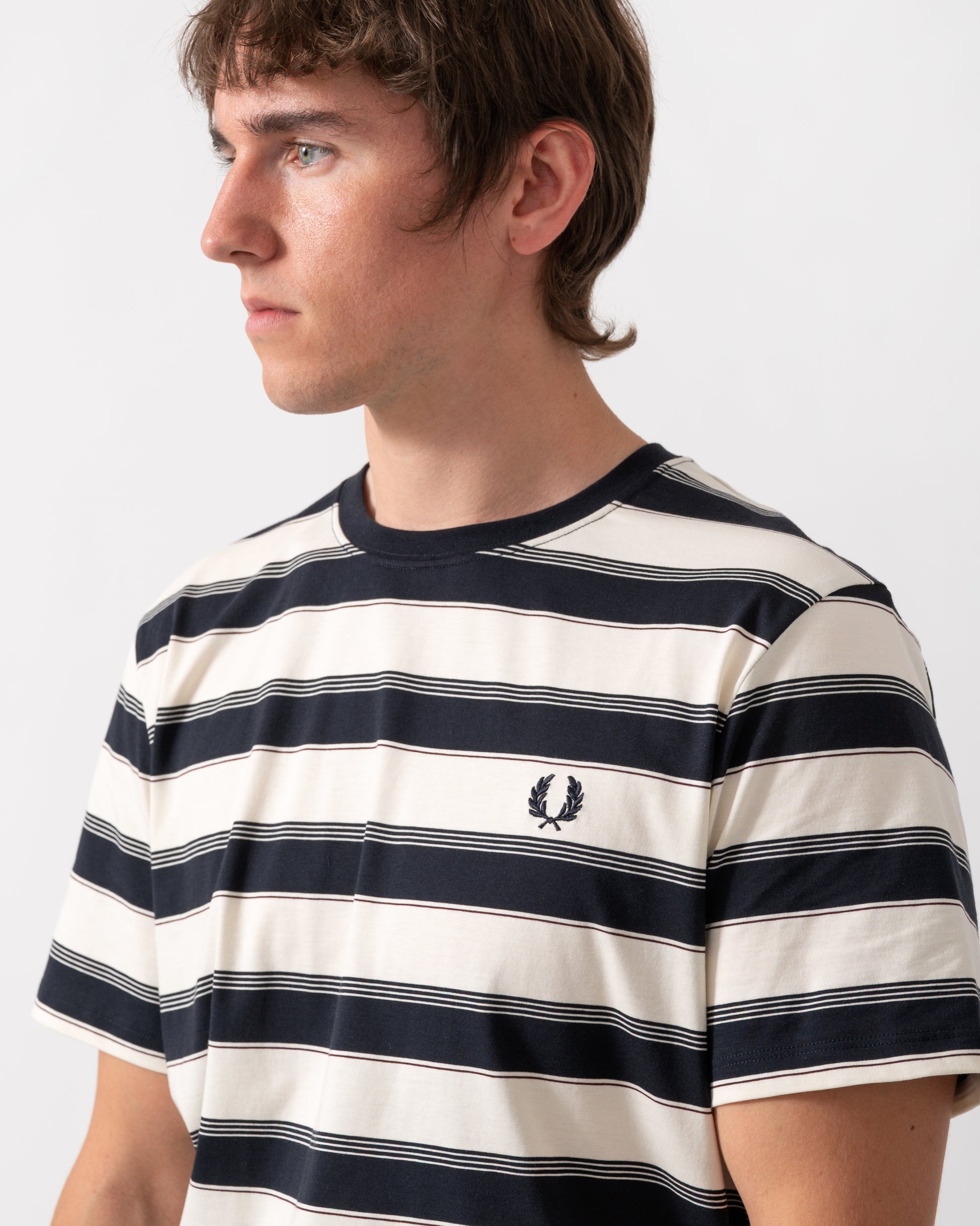 detail of a model wearing a Fred Perry Mens Fine Stripe T-Shirt in Navy 608