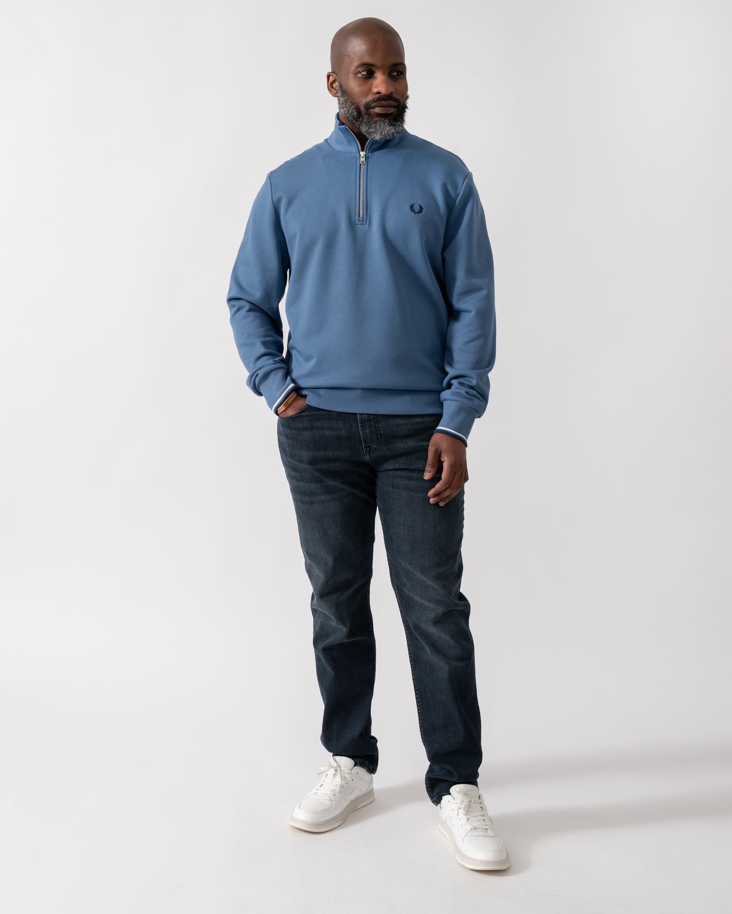 Full length shot of a Model wearing a Fred Perry Mens Half Zip Sweatshirt in Ace Blue with Tennis Blue logo