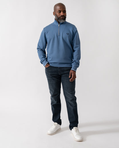 Full length shot of a Model wearing a Fred Perry Mens Half Zip Sweatshirt in Ace Blue with Tennis Blue logo