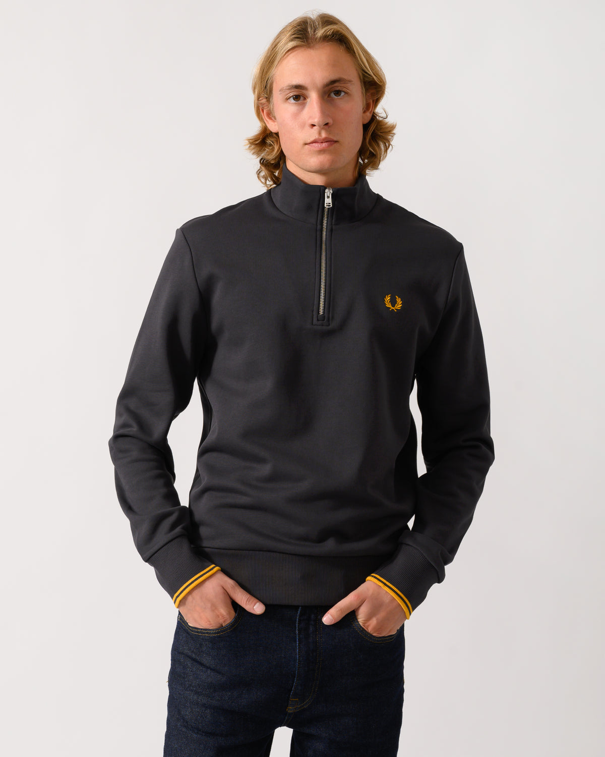 studio photograph of a model wearing a Fred Perry Mens Half Zip Sweatshirt in Anchor Grey/Golden 85C