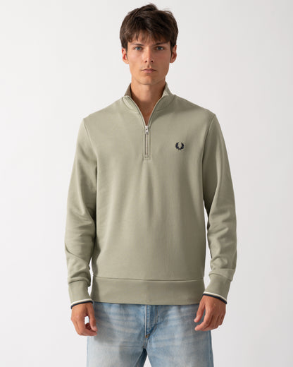 model wearing a Fred Perry Mens Half Zip Sweatshirt in Seagrass with Ecru and Dark Airforce trim