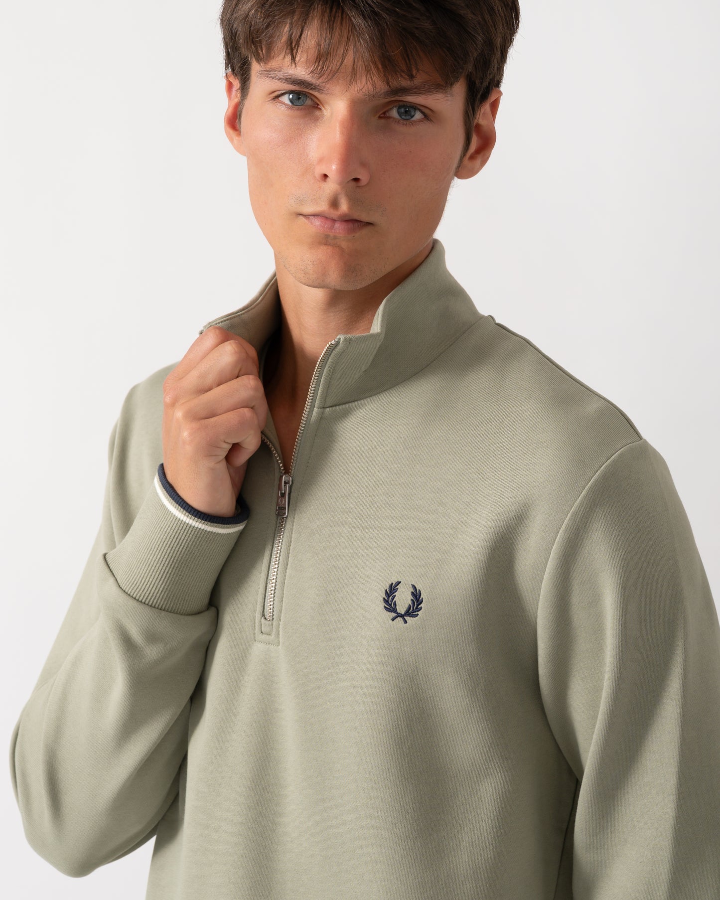 close up of a model wearing a Fred Perry Mens Half Zip Sweatshirt in Seagrass with Ecru and Dark Airforce trim