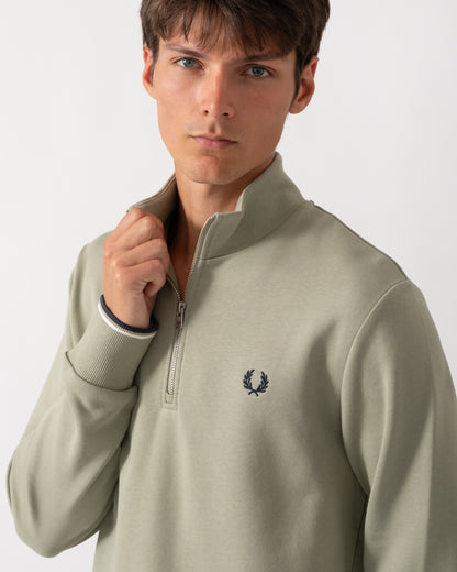 close up of a model wearing a Fred Perry Mens Half Zip Sweatshirt in Seagrass with Ecru and Dark Airforce trim
