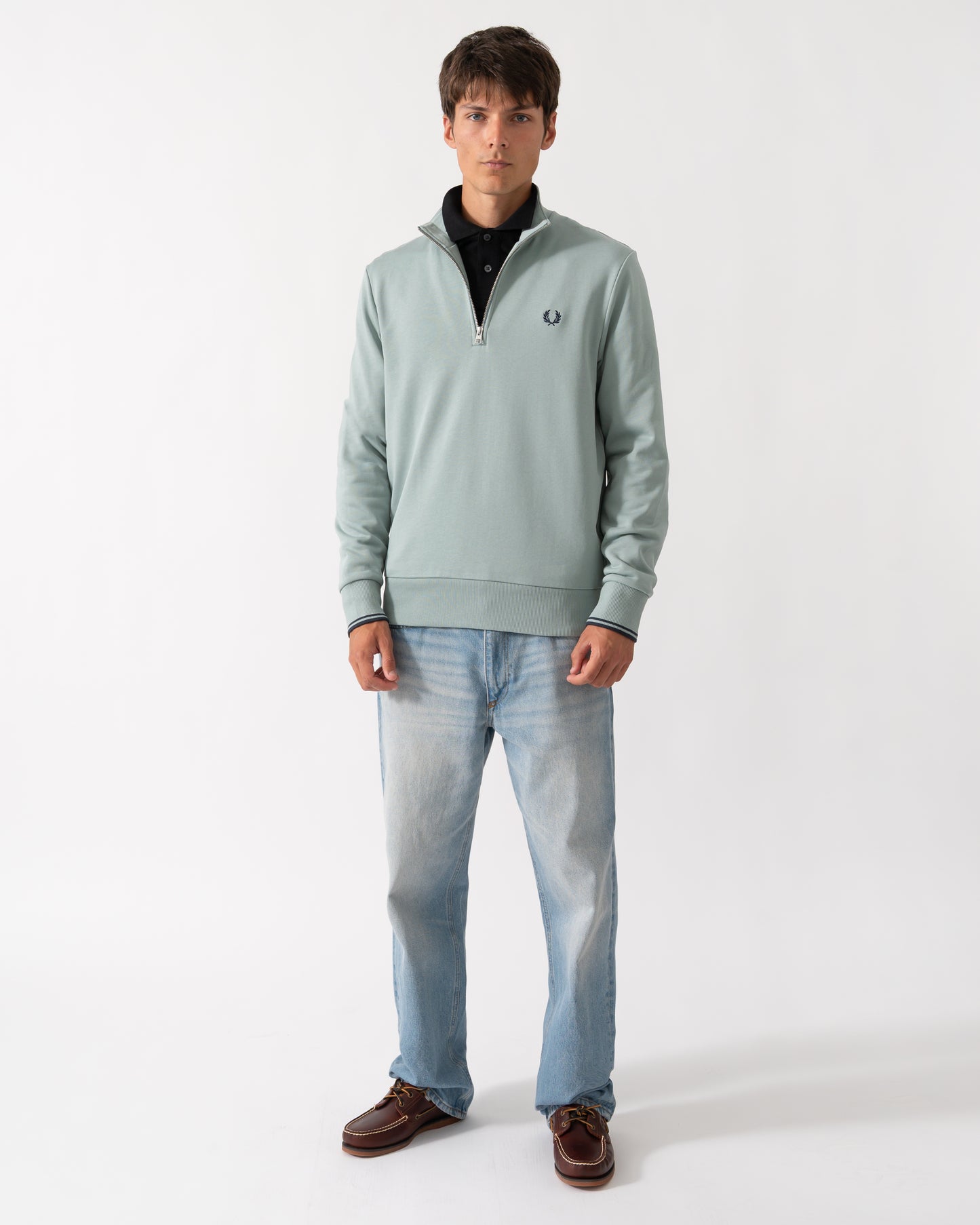 full length shot of a model wearng a Fred Perry Mens Half Zip Sweatshirt in Silver Blue/Dark Airforce 71C