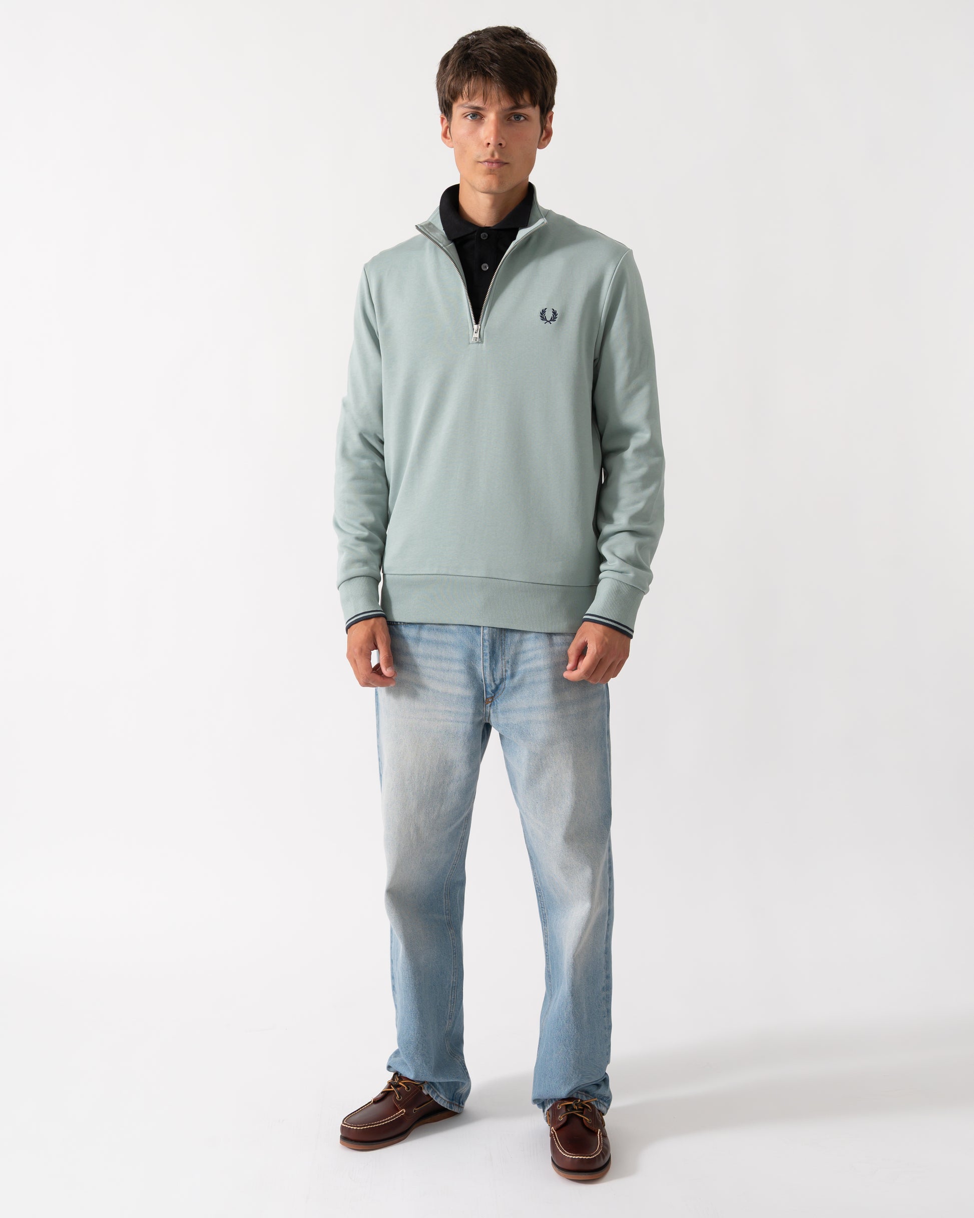 full length shot of a model wearng a Fred Perry Mens Half Zip Sweatshirt in Silver Blue/Dark Airforce 71C