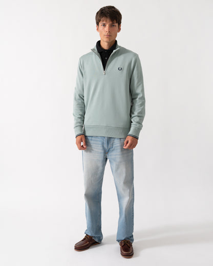 full length shot of a model wearng a Fred Perry Mens Half Zip Sweatshirt in Silver Blue/Dark Airforce 71C