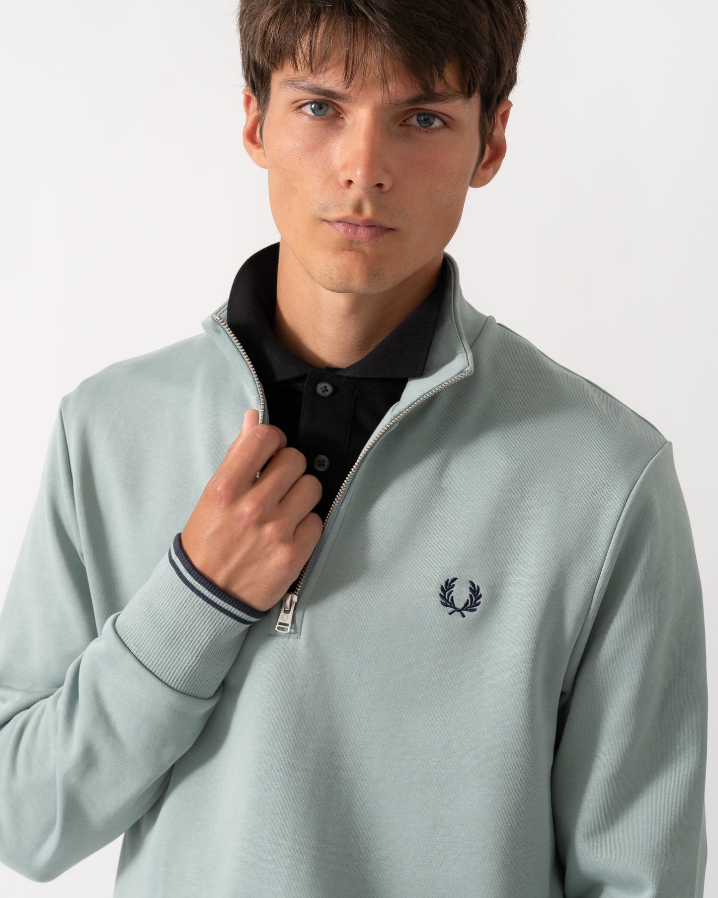 close up of a model wearng a Fred Perry Mens Half Zip Sweatshirt in Silver Blue/Dark Airforce 71C