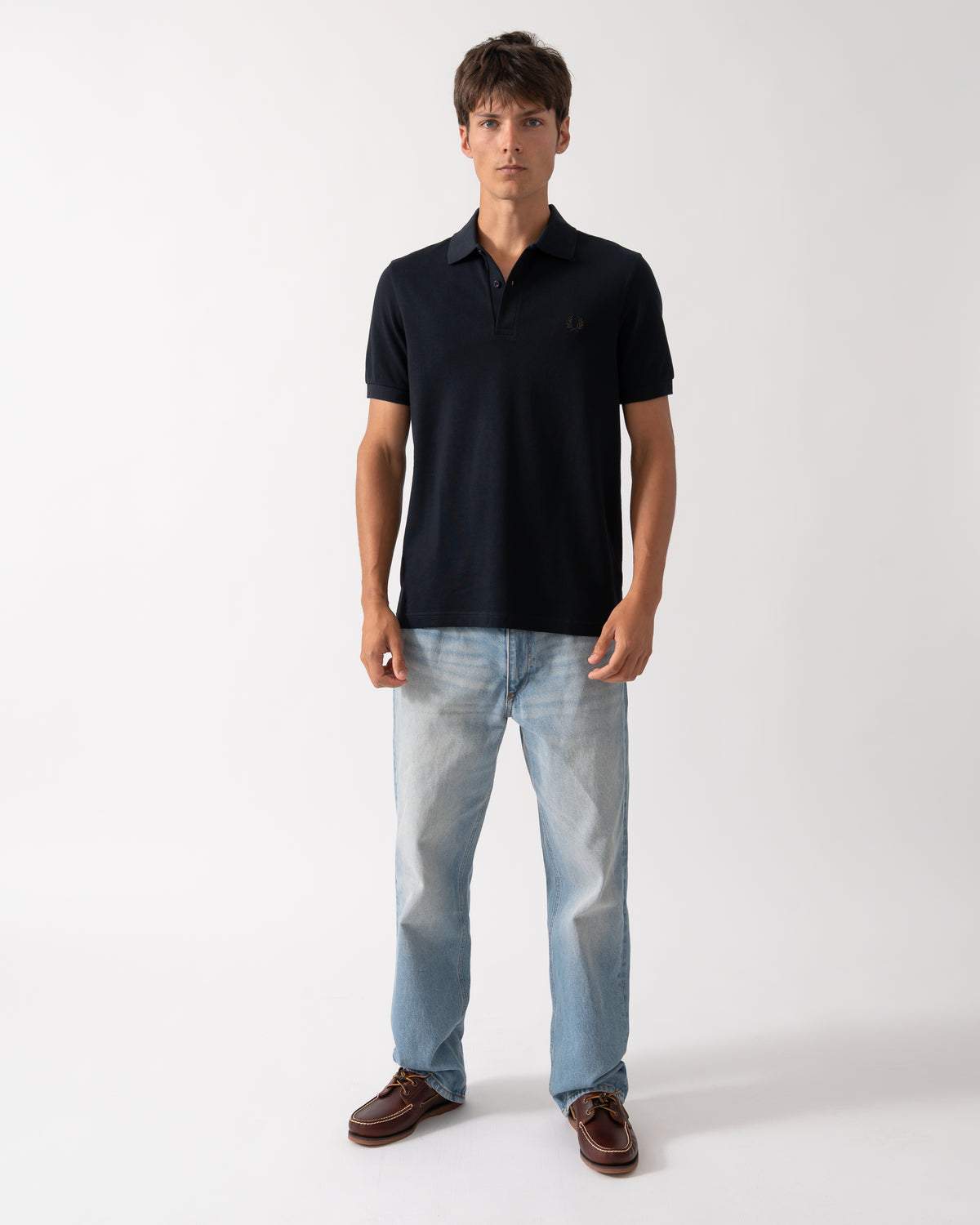 full length of a model wearing a Fred Perry Mens Plain Signature Polo Shirt in Navy with Rich Brown trim