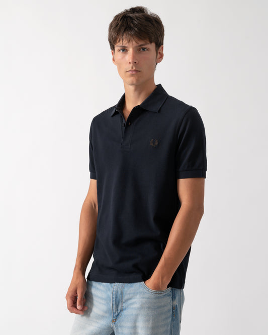model wearing a Fred Perry Mens Plain Signature Polo Shirt in Navy with Rich Brown trim