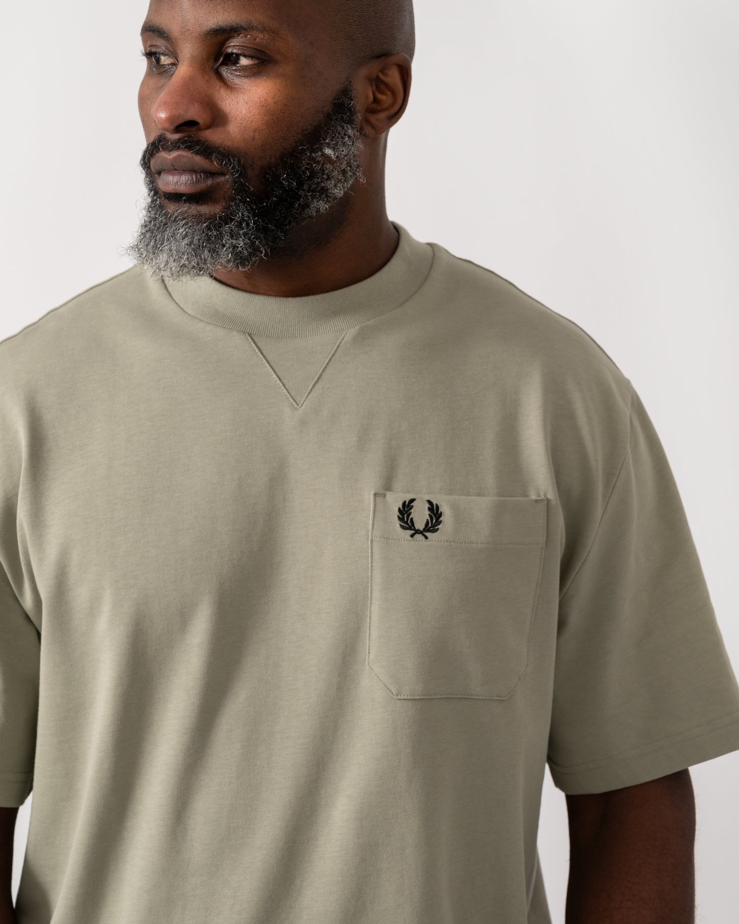 detail shot of a Model wearing a Fred Perry Mens Pocket Detail T-Shirt in Seagrass
