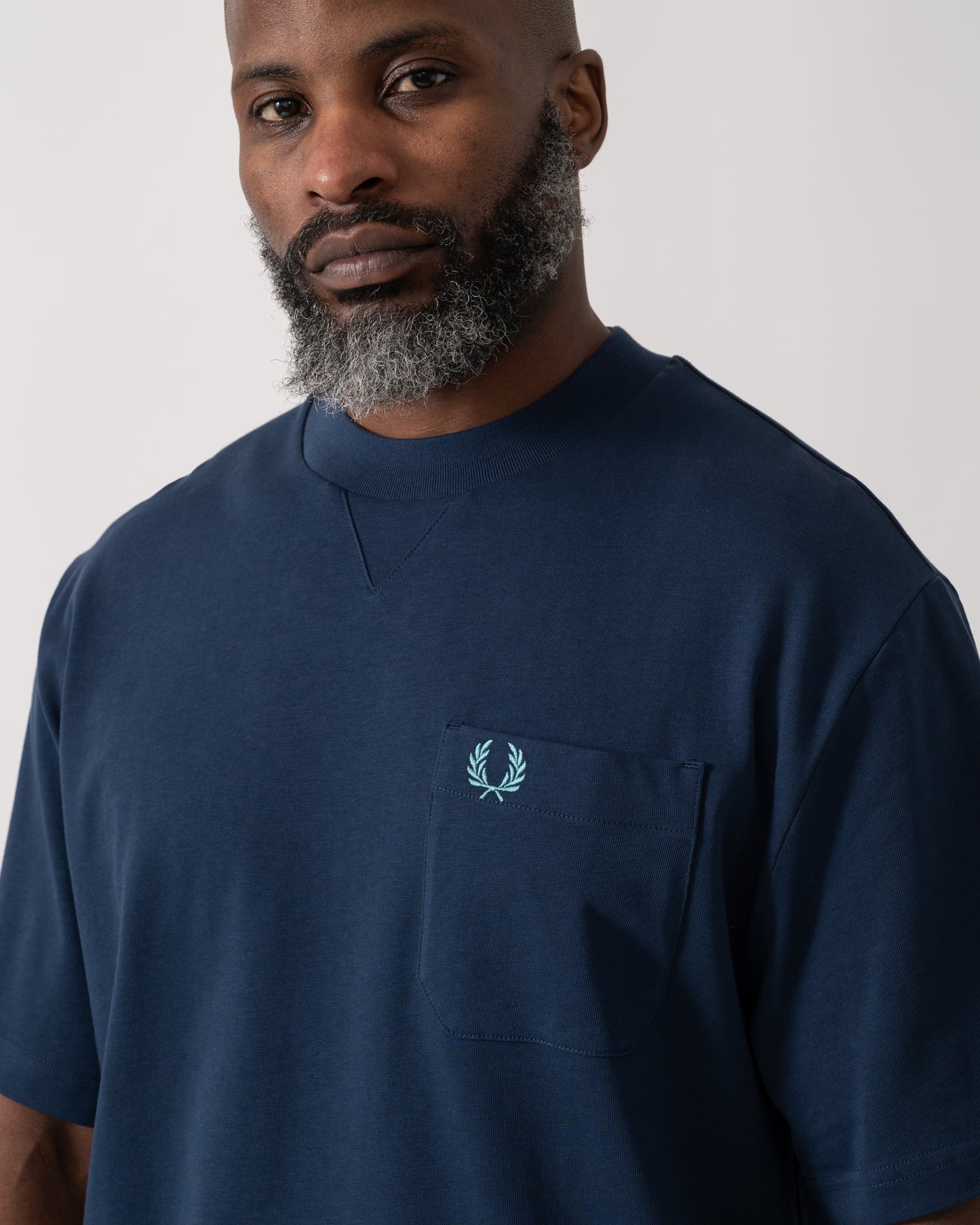 close up shot of a Model wearing a Fred Perry Mens Pocket Detail T-Shirt in Tennis Blue