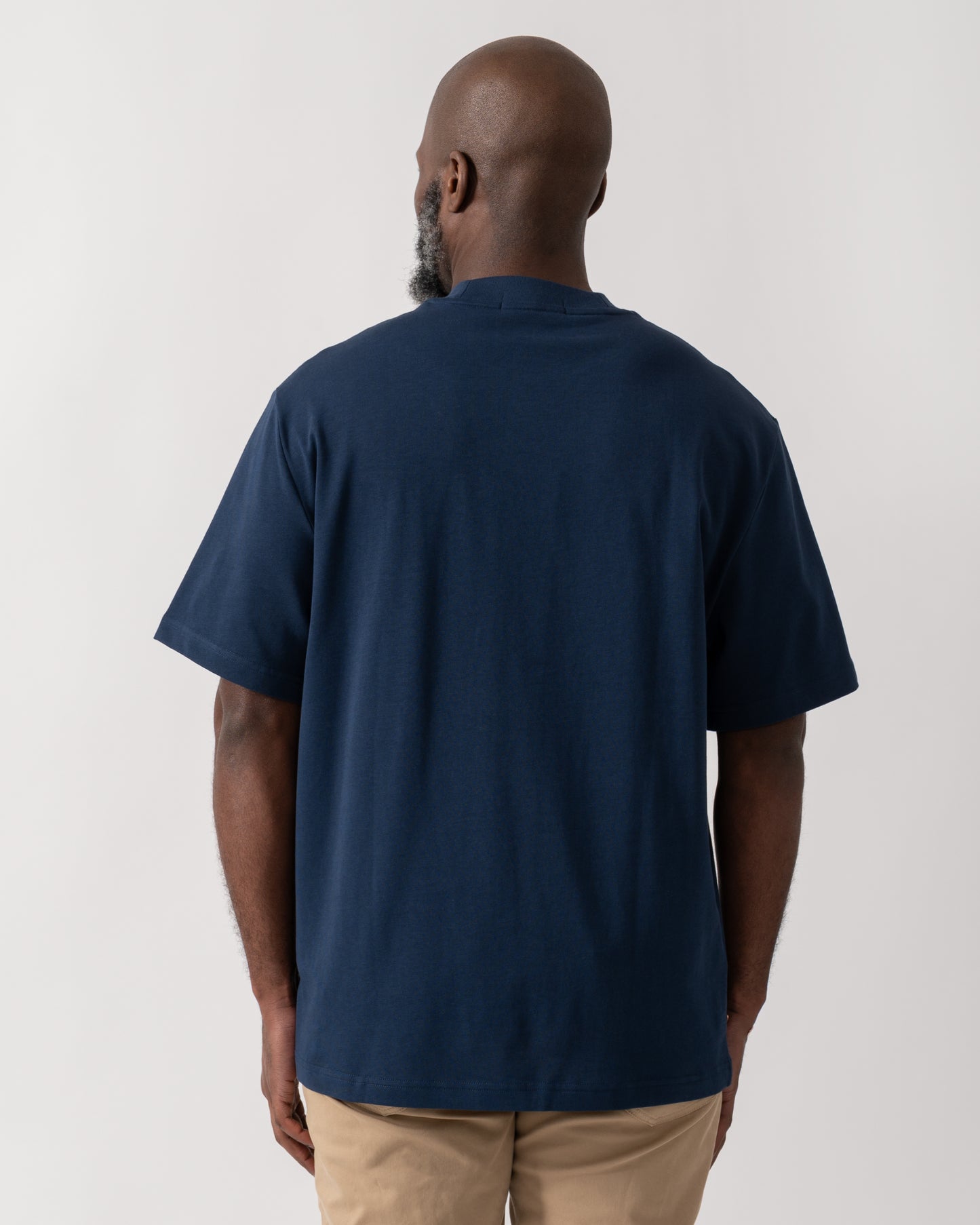 back shot of a Model wearing a Fred Perry Mens Pocket Detail T-Shirt in Tennis Blue
