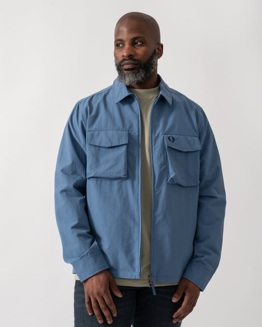 Model wearing a Fred Perry Mens Ripstop Pocket Overshirt in Ace Blue