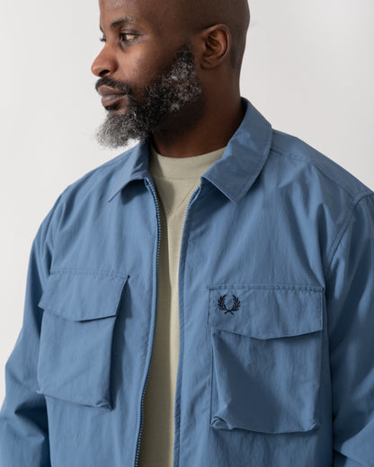 detail shot of a Model wearing a Fred Perry Mens Ripstop Pocket Overshirt in Ace Blue