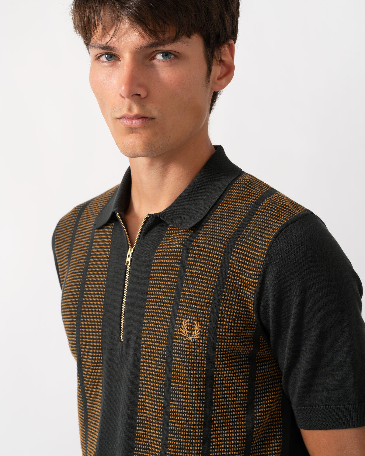 close up of model wearing a Fred Perry Mens Textured Panel Knitted Polo Shirt in Night Green Q20
