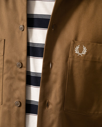 logo detail of a model wearing a Fred Perry Mens Twill Overshirt in Shaded Stone P96