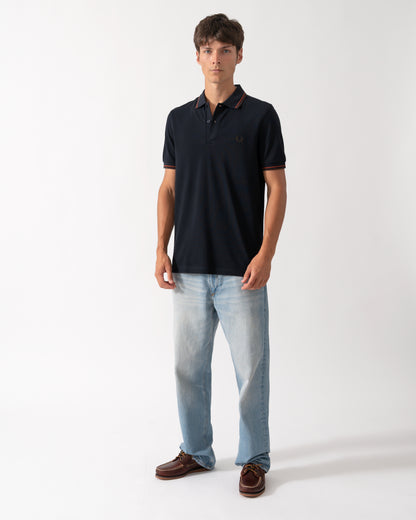 full length shot of a model wearing a Fred Perry Mens Twin Tipped Signature Polo Shirt in Navy with Burgundy and Rich brown trim