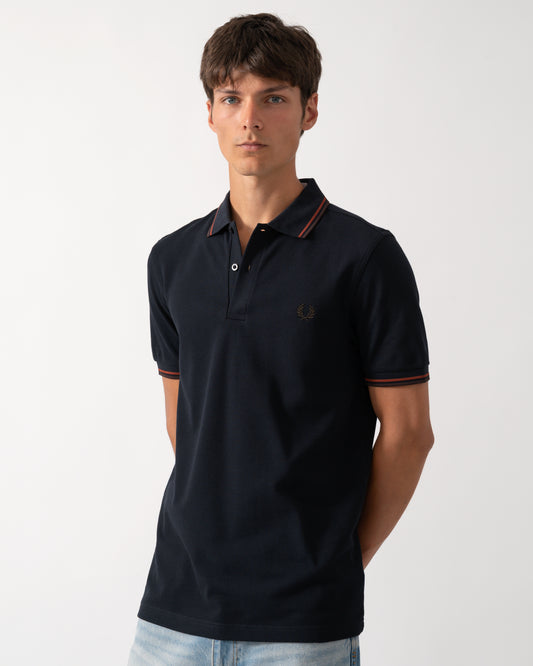 model wearing a Fred Perry Mens Twin Tipped Signature Polo Shirt in Navy with Burgundy and Rich brown trim