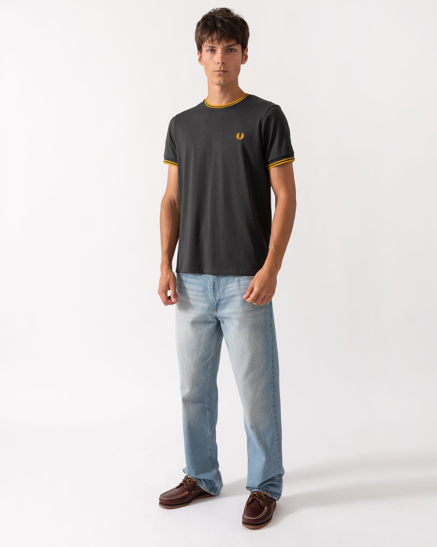 full length of a model wearing a Fred Perry Mens Twin Tipped T-Shirt in Anchor Grey-Golden 85C