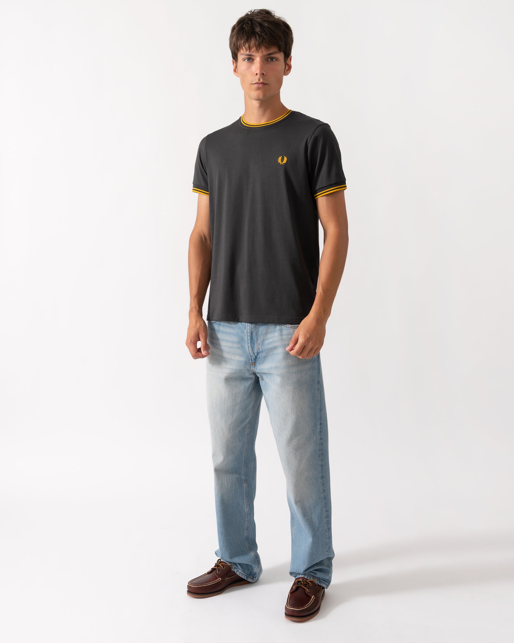 full length of a model wearing a Fred Perry Mens Twin Tipped T-Shirt in Anchor Grey-Golden 85C