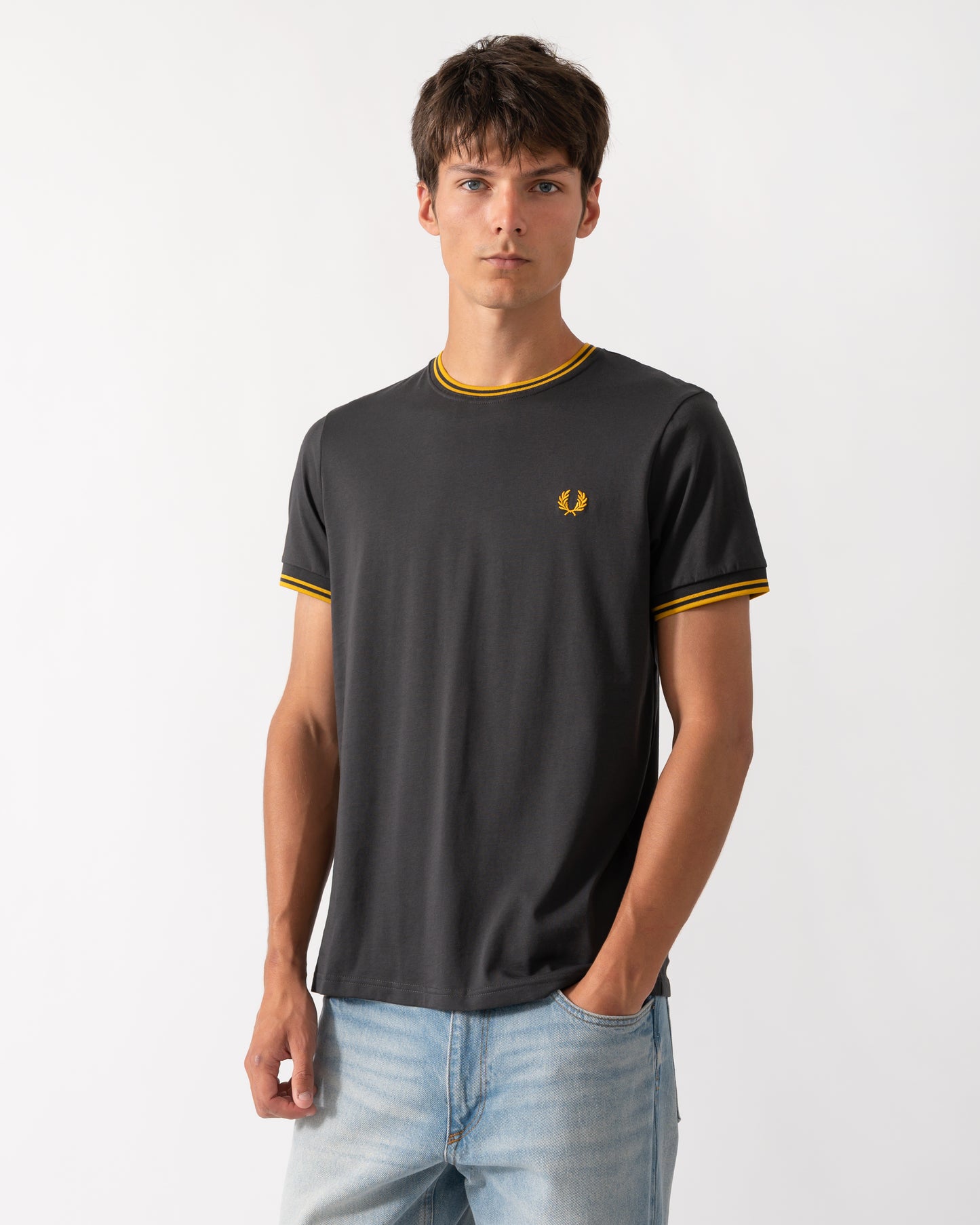 model wearing a Fred Perry Mens Twin Tipped T-Shirt in Anchor Grey-Golden 85C