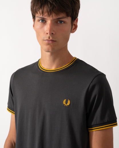 close up of model wearing a Fred Perry Mens Twin Tipped T-Shirt in Anchor Grey-Golden 85C