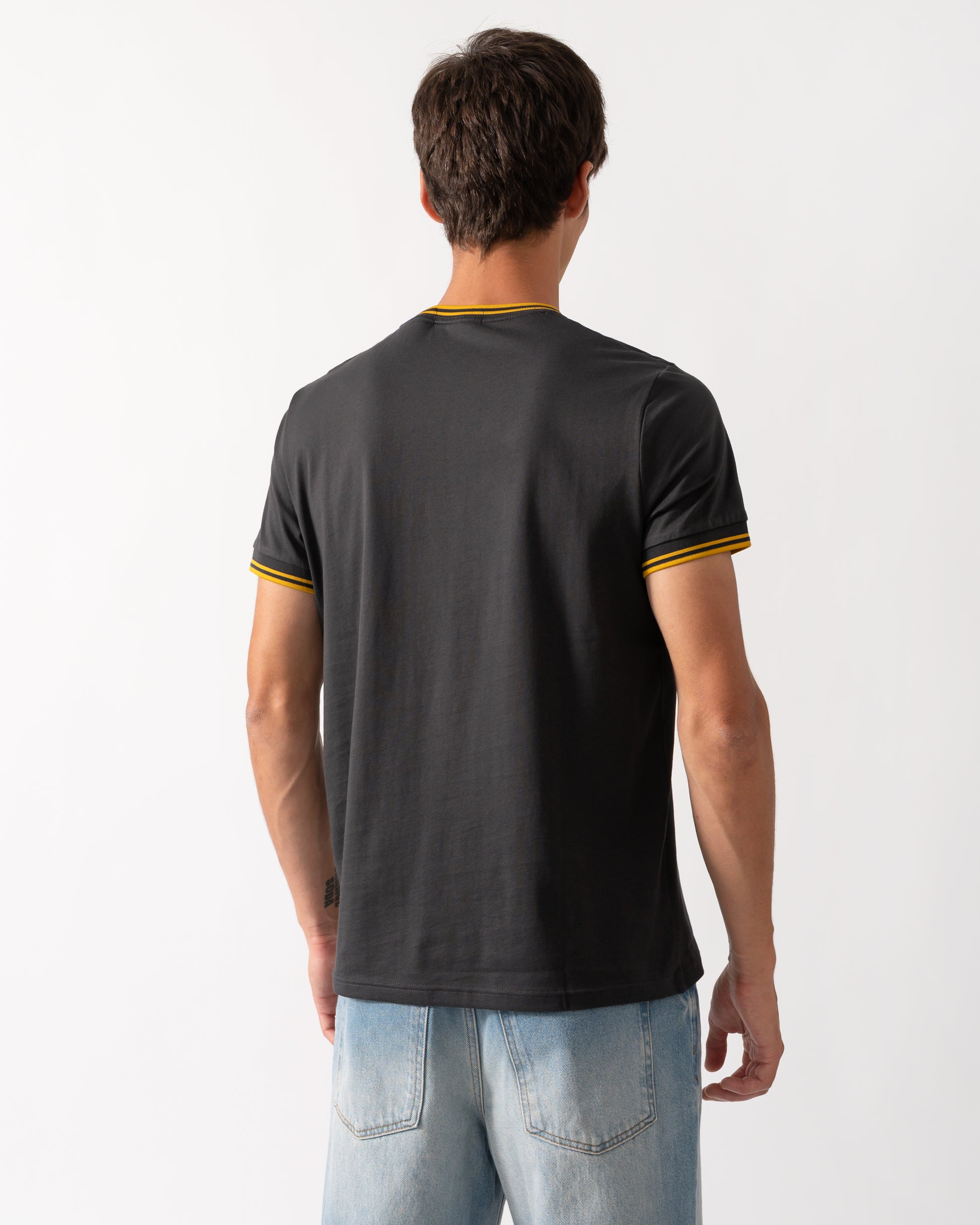 back shot of a model wearing a Fred Perry Mens Twin Tipped T-Shirt in Anchor Grey-Golden 85C