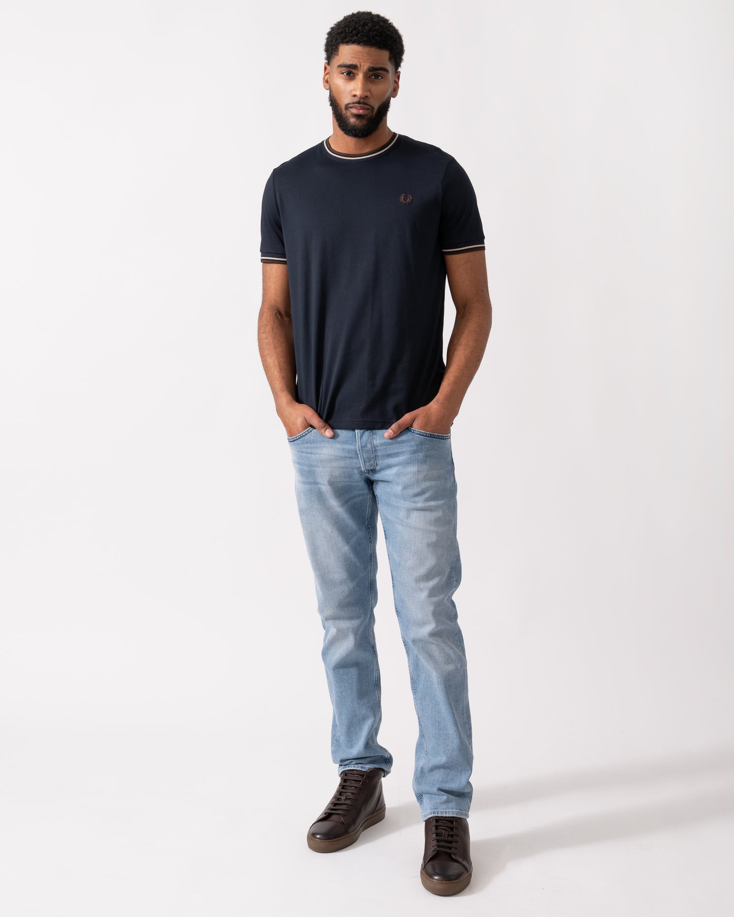 Full length shot of a Model wearing a Fred Perry Mens Twin Tipped T-Shirt  in Navy with Warm Oatmeal and Burnt Tobacco trim