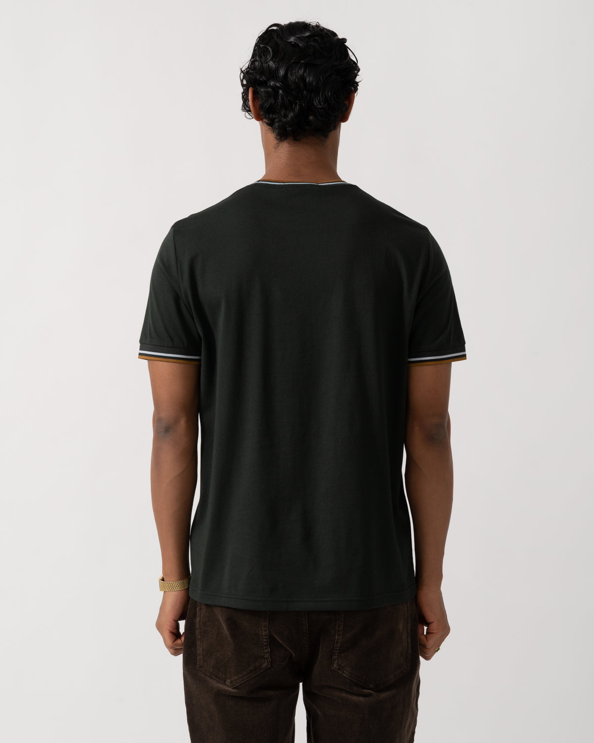 studio photograph showing the back of a model wearing a Fred Perry Mens Twin Tipped T-Shirt in Night Green with Dusk Blue and Dark Caramel trim 78C