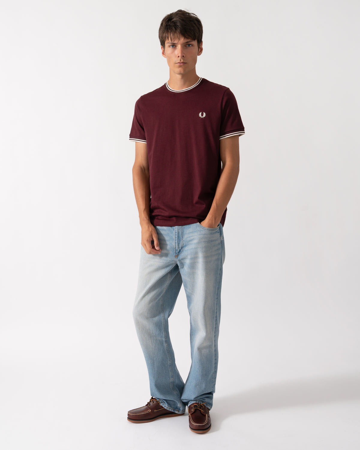 full length of a model wearing a Fred Perry Mens Twin Tipped T-Shirt in Oxblood with Ecru trim