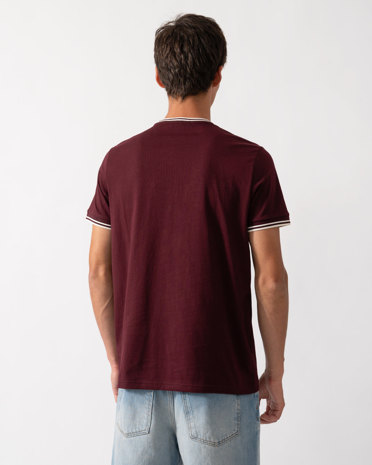 back of a model wearing a Fred Perry Mens Twin Tipped T-Shirt in Oxblood with Ecru trim