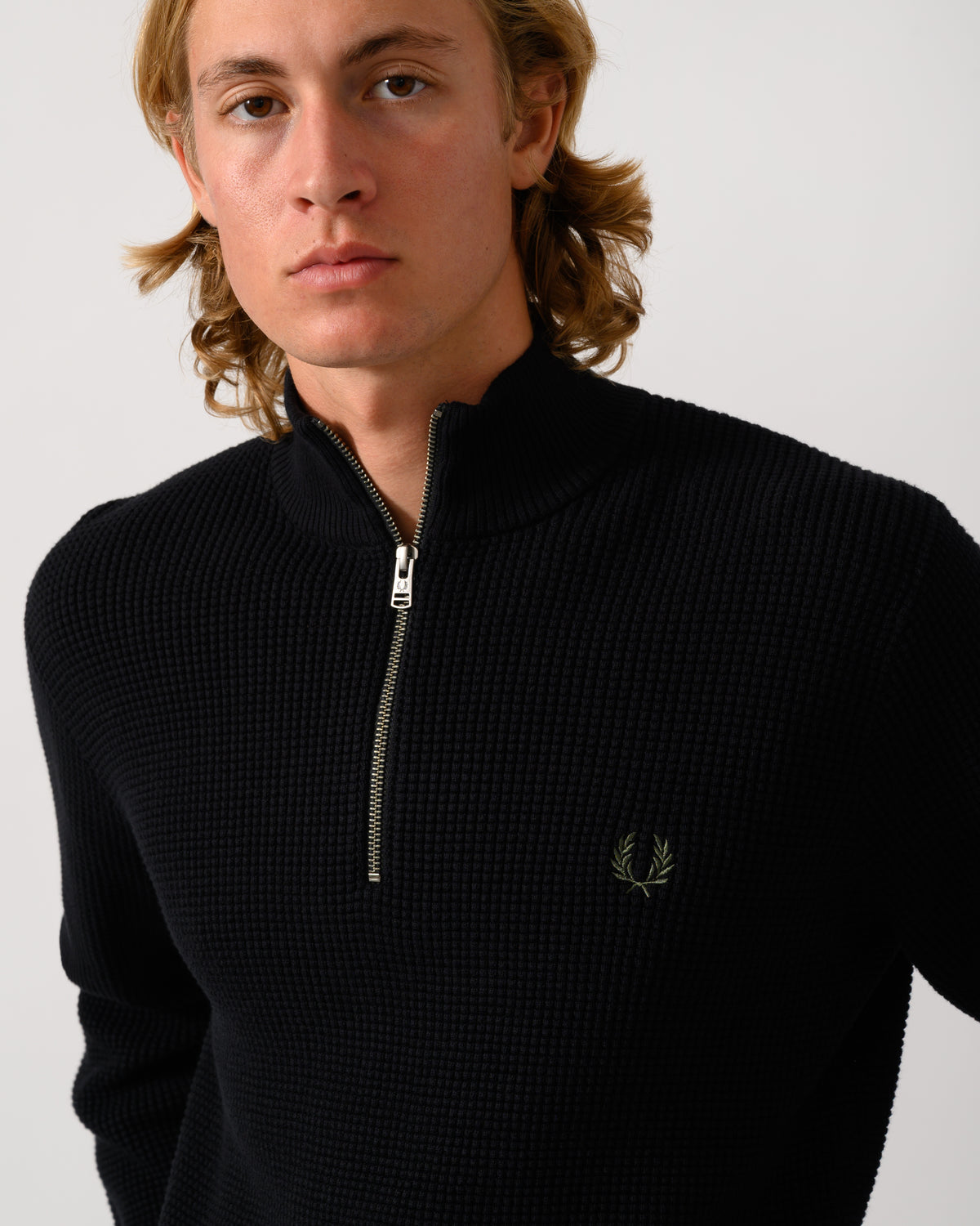 close ip o fa model wearing a Fred Perry Mens Waffle Stitch Half Zip Jumper in Black 198