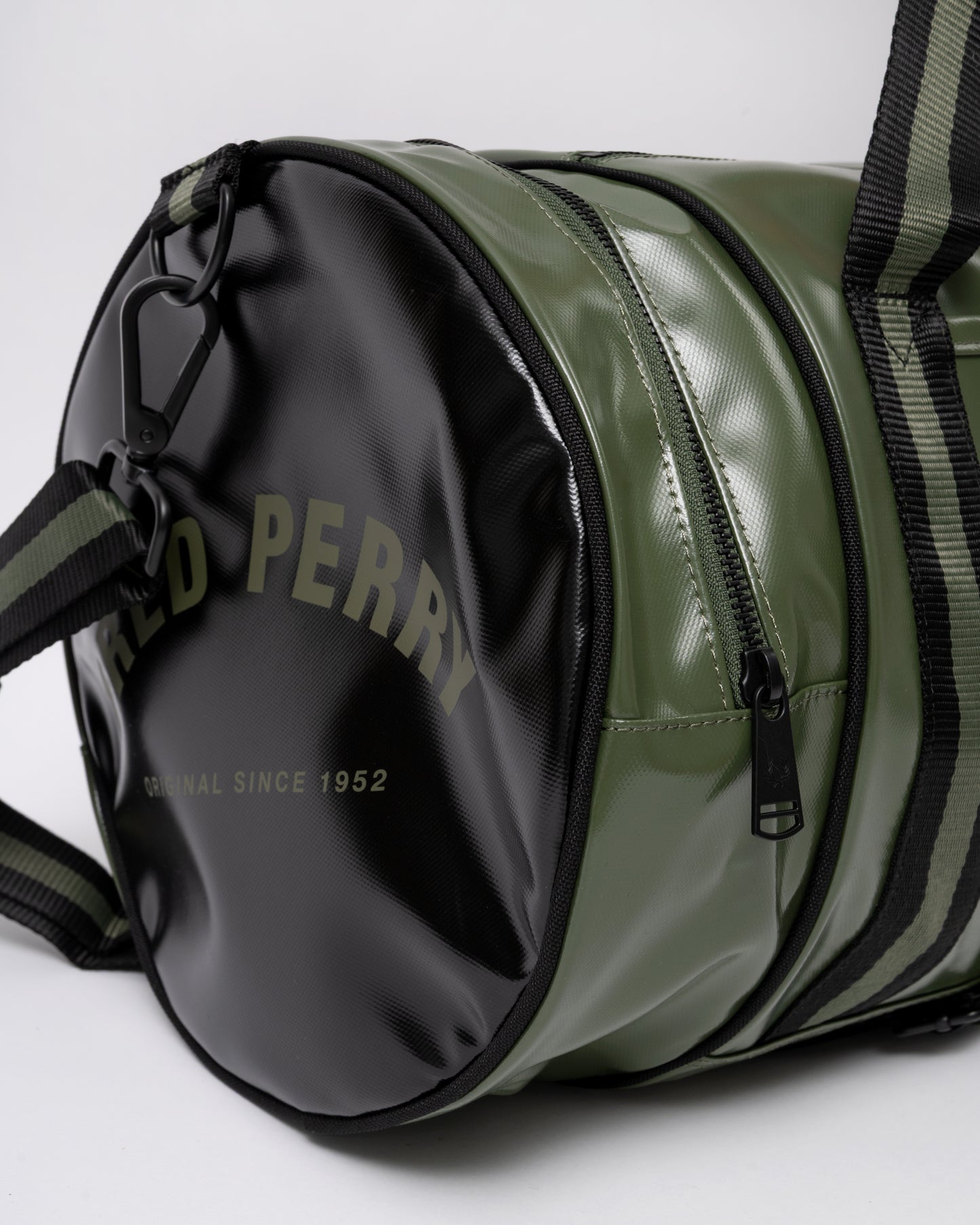 end pocket detail of Fred Perry Recycled Polyester Classic Barrel Bag in Laurel Wreath Green and Black Z50