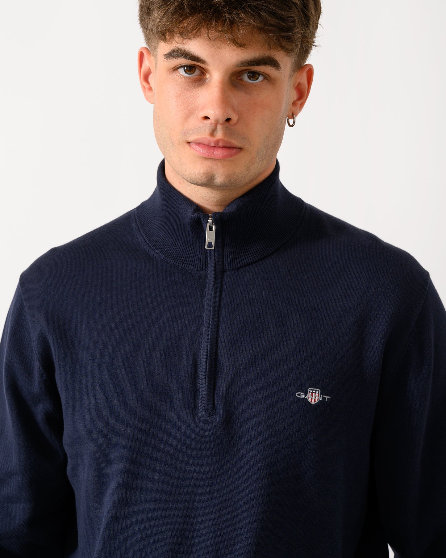 close up shot of a model wearing a GANT Mens Classic Cotton Shield Logo Half Zip Jumper n 433 Evening Blue