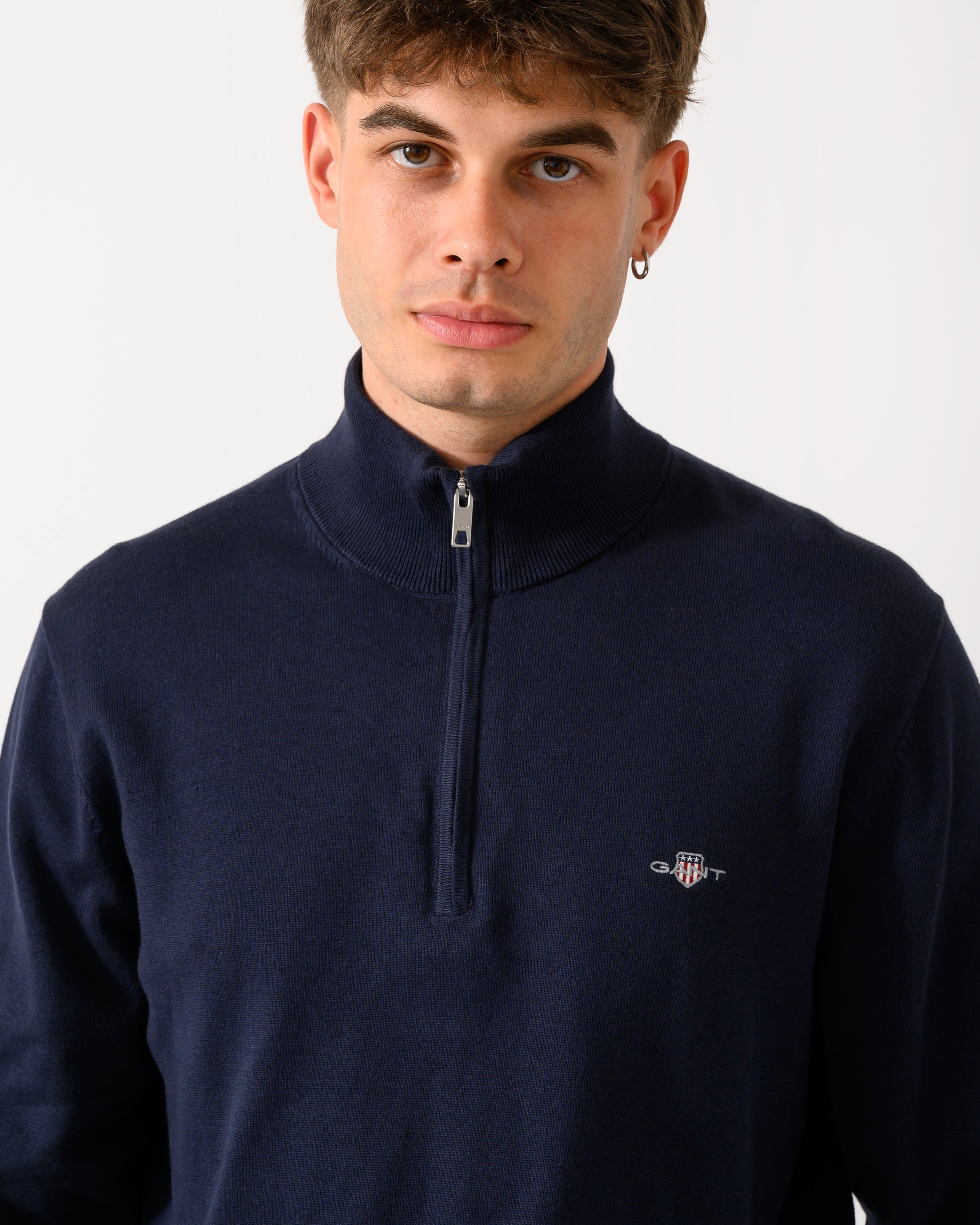 close up shot of a model wearing a GANT Mens Classic Cotton Shield Logo Half Zip Jumper n 433 Evening Blue
