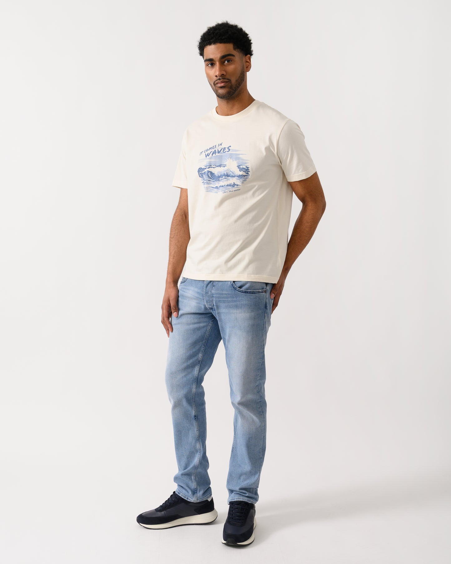 full length shot of a model wearing a GANT Mens Graphic Short Sleeve T-Shirt in 130 Cream