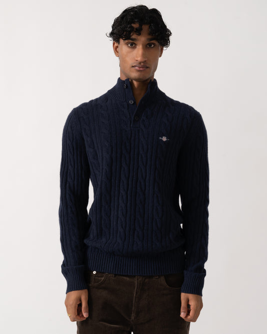 studio photograph of a model wearing a GANT Mens Lambswool Cable Half Button Sweater in 433 Evening Blue