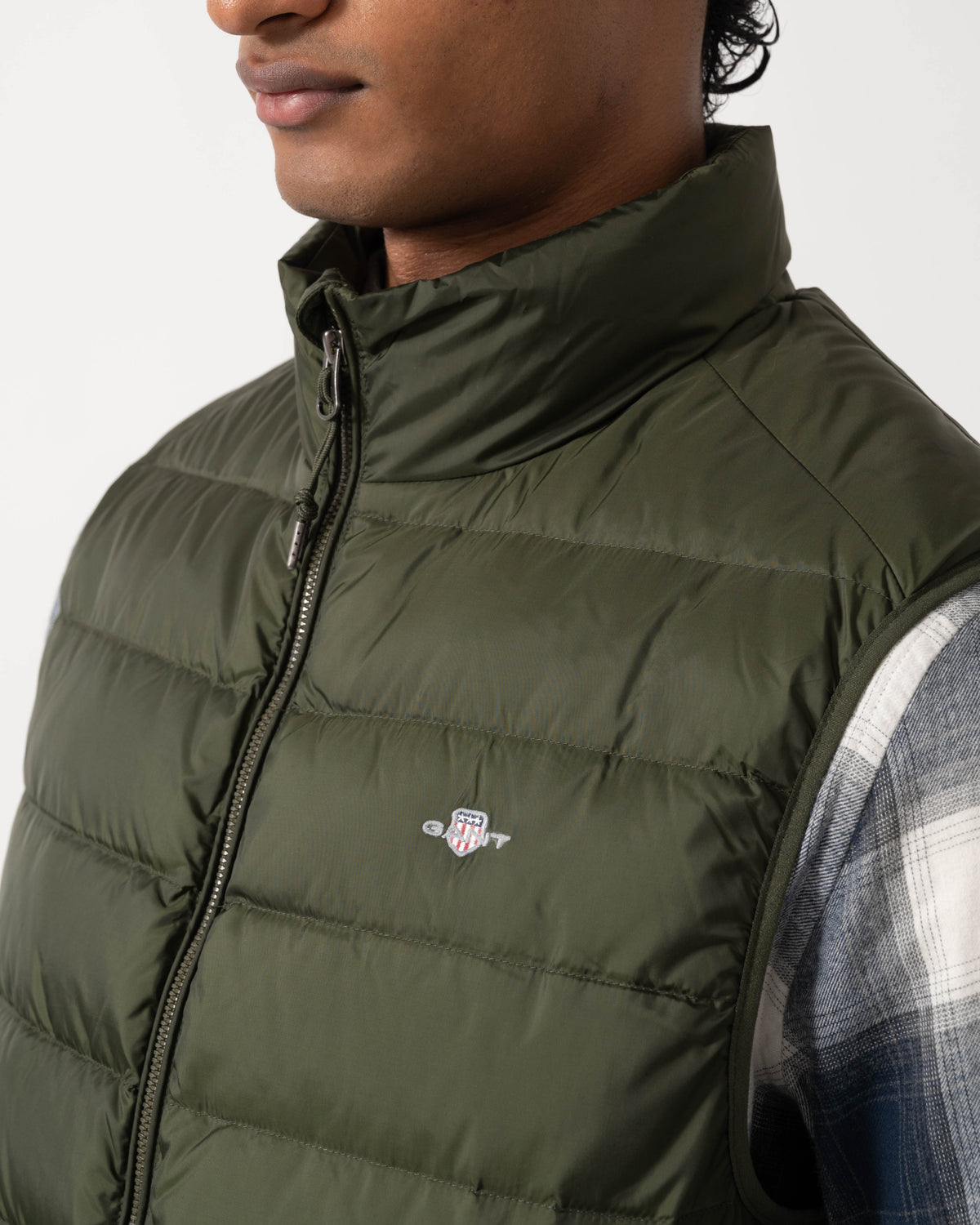 Close up of the GANT Mens Light Down Shield Logo Gilet - 368 Dark Moss Green