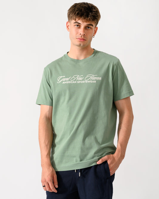 model wearing a GANT Mens Logo Graphic Short Sleeve T-Shirt in 308 Surplus Mint