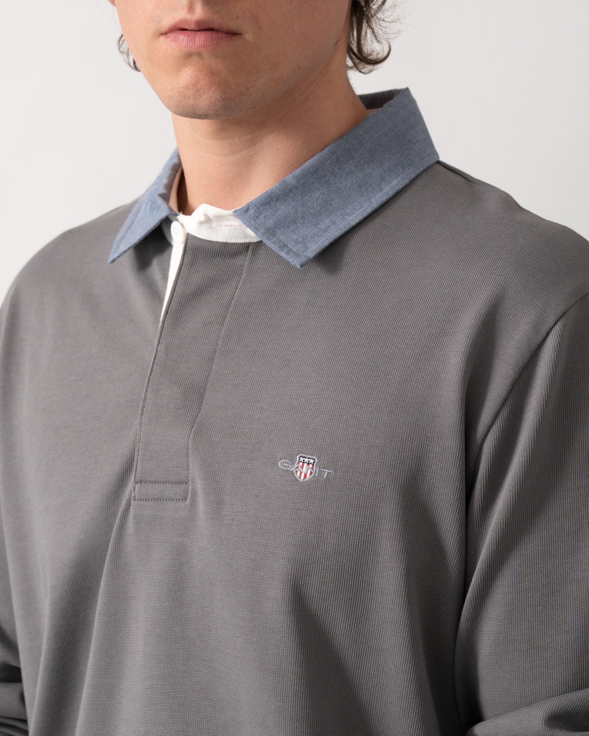 close up shot of a model wearing a GANT Mens Regular Fit Chambray Heavy Rugger in 38 Mid Grey