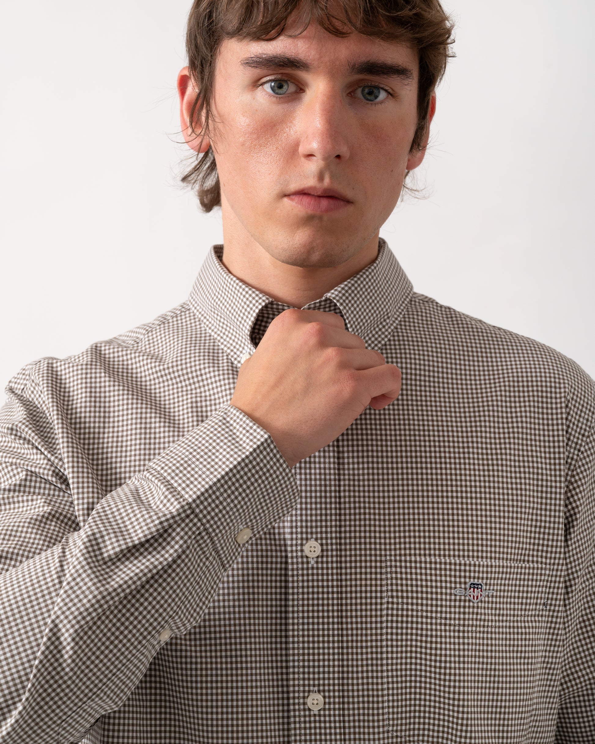 close up of model wearing a GANT Mens Regular Fit Classic Poplin Gingham Shirt in 260 Faded Taupe