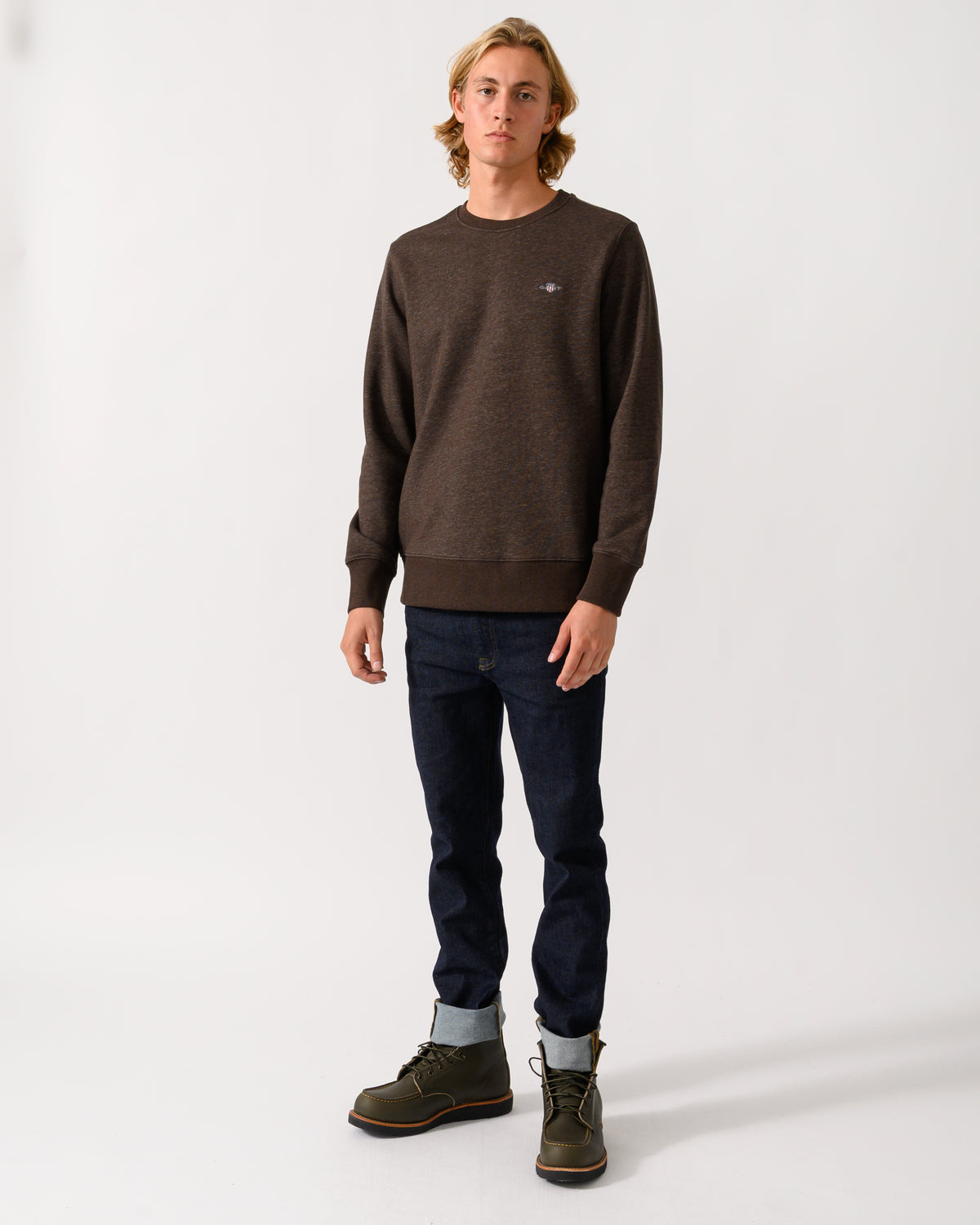 full length studio photograph of a model wearing a GANT Mens Regular Fit Shield Logo Crew Neck Sweatshirt in 284 Black Brown Melange