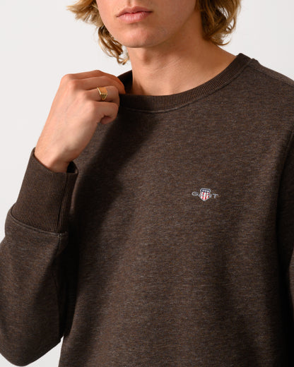 close up studio photograph of a model wearing a GANT Mens Regular Fit Shield Logo Crew Neck Sweatshirt in 284 Black Brown Melange