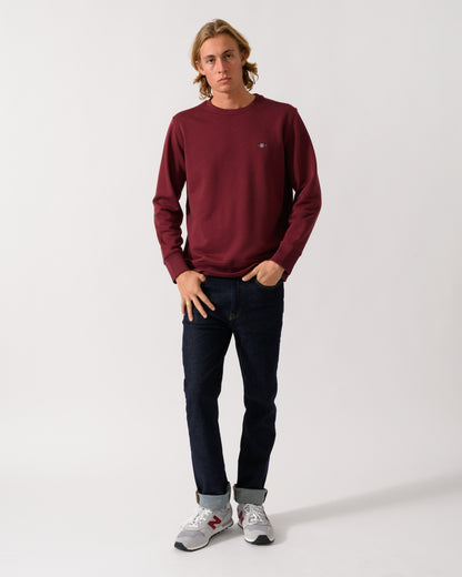 full length of a model wearing a GANT Mens Regular Fit Shield Logo Crew Neck Sweatshirt in 676 Deep Grape Wine