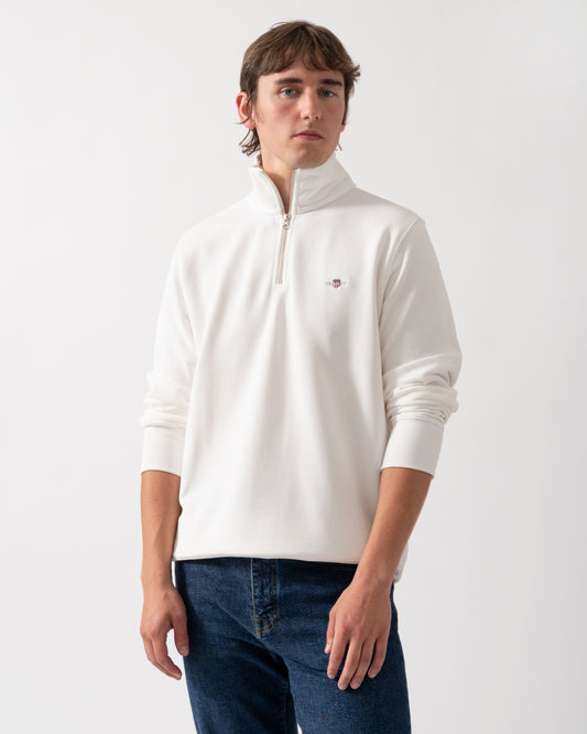 model wearing a GANT Mens Regular Fit Shield Logo Half Zip Sweatshirt in 113 Eggshell