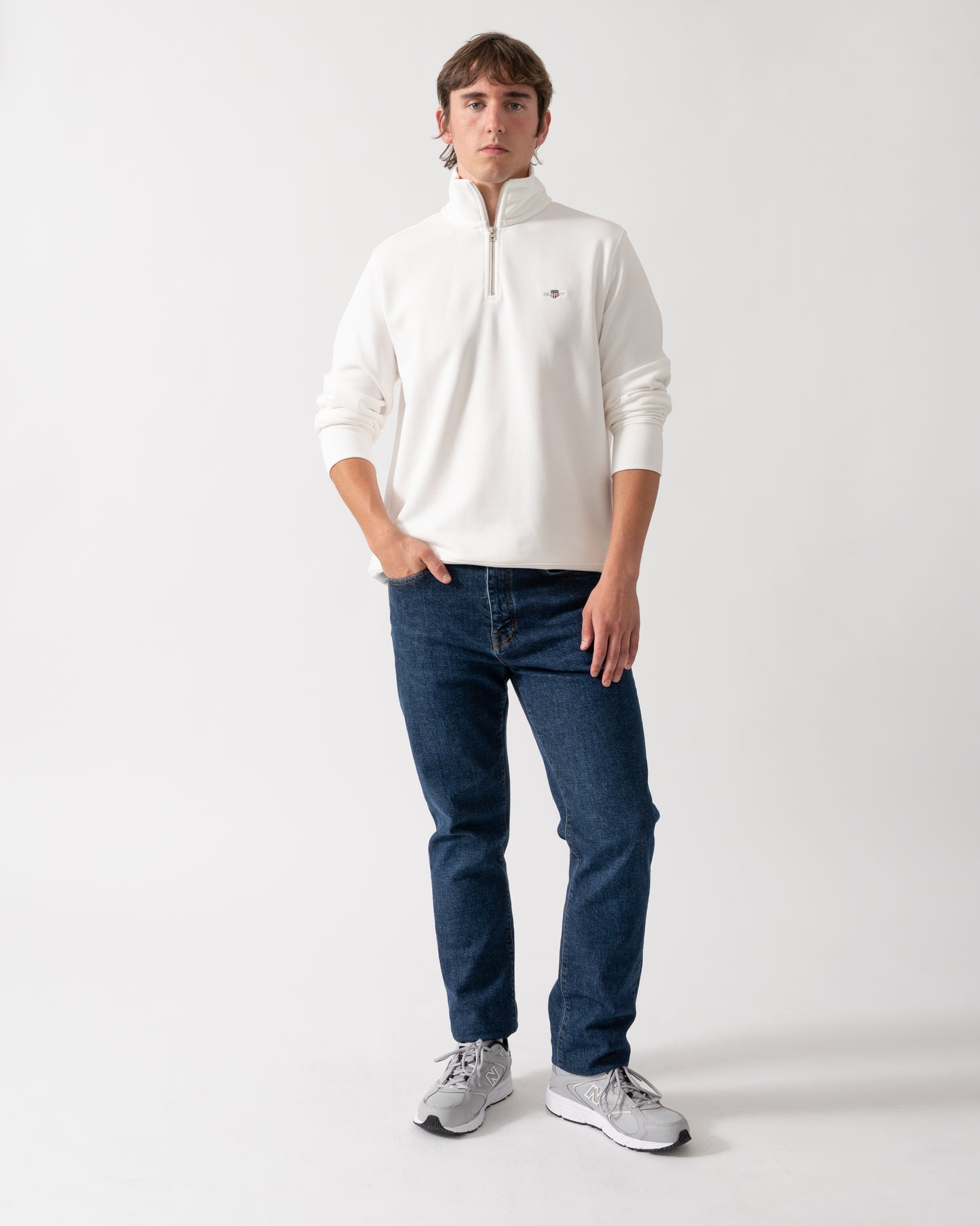 full length shot of a model wearing a GANT Mens Regular Fit Shield Logo Half Zip Sweatshirt in 113 Eggshell